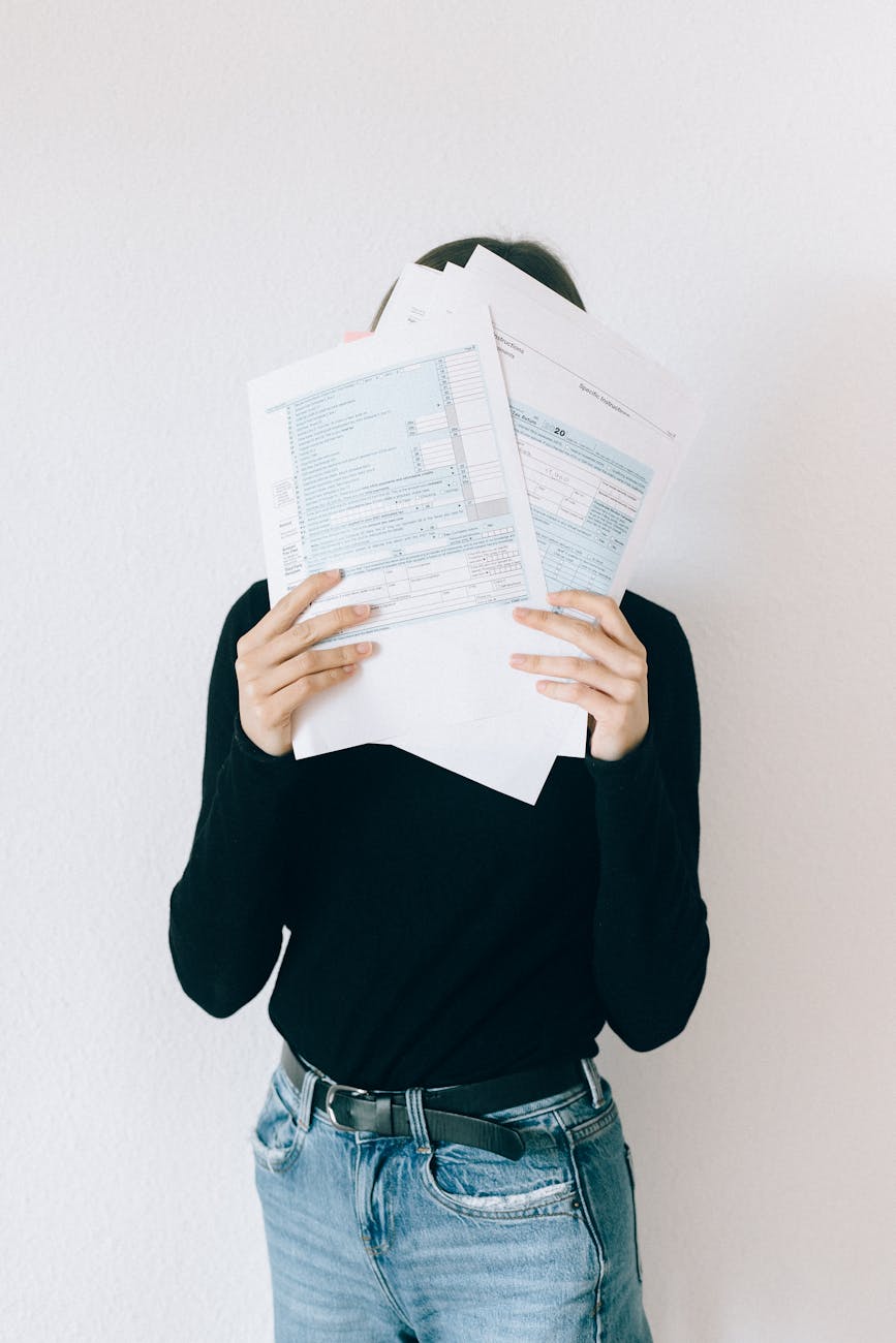 woman covering her face with tax forms